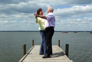 happy couple dancing on a dock